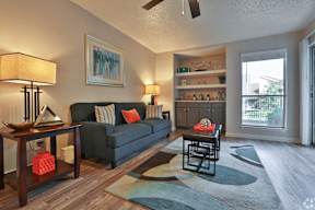 A living room with a couch, a table, and a painting on the wall.