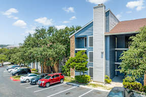 A parking lot with cars and a building in the background.