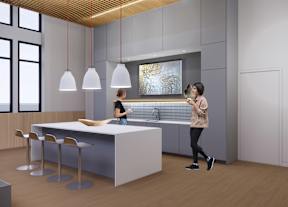 A woman is standing in a modern kitchen with a bar area and a woman is standing at the bar area.