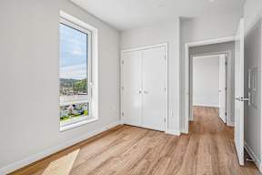 A room with a large window and wooden floors.