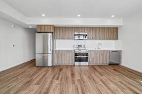 A modern kitchen with wooden cabinets and stainless steel appliances.