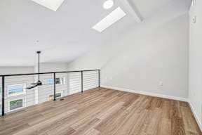 A room with wooden flooring and a black metal railing.