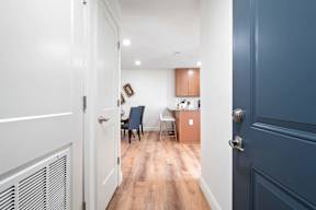A hallway with a blue door and a white door.