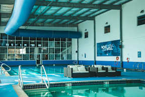 A pool with a sign that says "Move Well" on the wall.