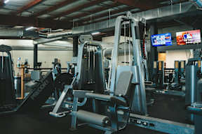 A gym with a variety of equipment including a weight bench.