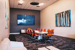A conference room with a long table and chairs.
