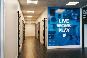 A hallway with a blue poster that says "Live Work Play".