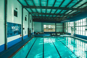 A swimming pool in a large indoor swimming pool with a sign that says "Move, Live, Well.".