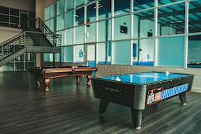 A pool table in a room with a staircase.