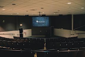A large auditorium with a screen displaying "The Retreat".