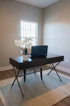 A laptop is on a table with flowers.
