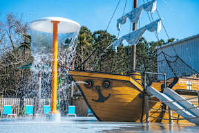 A water park with a pirate ship slide and a water cannon.