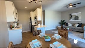 A modern kitchen with a dining table set for two.
