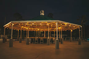 A gazebo is lit up at night.