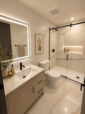A bathroom with a marble countertop and a walk-in shower.