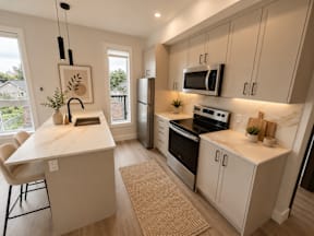 A kitchen with a white counter top and a refrigerator.
