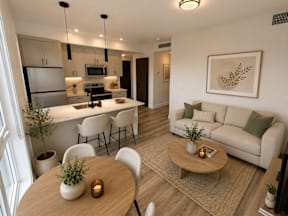 A modern living room with a dining area and kitchen in the background.