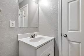 A white bathroom sink with a mirror above it.