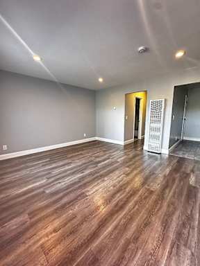 an empty living room with a hard wood floor