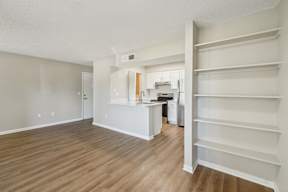 A room with a kitchen area and a staircase.