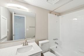 A white bathroom with a sink, toilet, and bathtub.