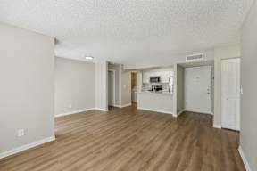 A room with wooden flooring and white walls.