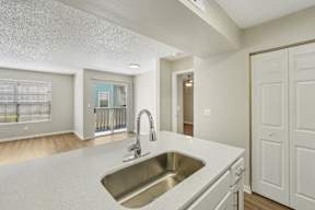 A kitchen with a sink and a white counter top.