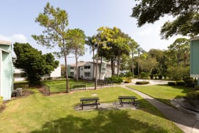 a park with two benches in front of some houses