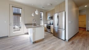 a kitchen with stainless steel appliances and a wooden floor