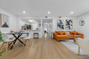 a living room and dining room with white walls and hardwood floors