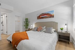 a bedroom with a large bed and a painting on the wall