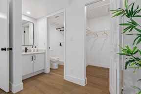 a bathroom with white walls and wood flooring