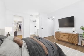 a bedroom with a large bed and a tv on the wall