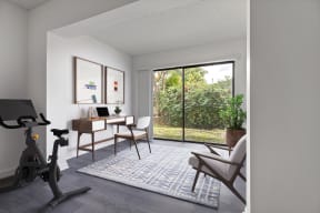 a workspace with a desk chair and exercise bike in a 555 waverly unit