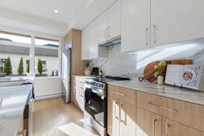 A modern kitchen with a stainless steel refrigerator and wooden cabinets in Hillcrest Ave located in Abbotsford, BC