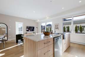 A modern kitchen with wooden cabinets and a large island in Hillcrest Ave located in Abbotsford, BC