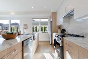 A modern kitchen with wooden cabinets and stainless steel appliances in Hillcrest Ave located in Abbotsford, BC