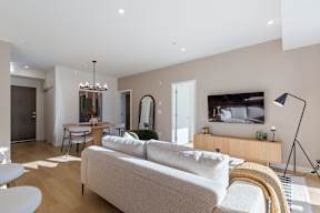 A modern living room with a white sofa and a television in Hillcrest Ave located in Abbotsford, BC