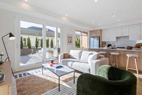 A modern living room with a green armchair and a glass table in Hillcrest Ave located in Abbotsford, BC