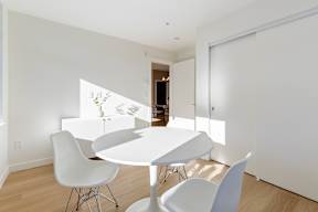 A white dining table with four chairs in a room in Hillcrest Ave located in Abbotsford, BC
