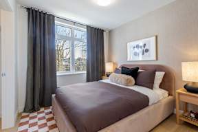 A bedroom with a large bed and a window with curtains in Hillcrest Ave located in Abbotsford, BC