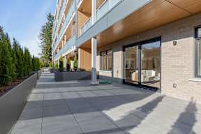 A long building with a balcony and a walkway in front in Hillcrest Ave located in Abbotsford, BC