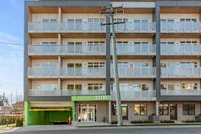 Image of  modern apartment building Hillcrest Ave with balconies and a green awning located in Abbotsford, BC