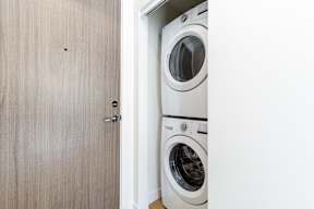 A white washing machine is in a small laundry room in Hillcrest Ave located in Abbotsford, BC