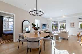 A modern dining room with a round table and grey chairs in Hillcrest Ave located in Abbotsford, BC