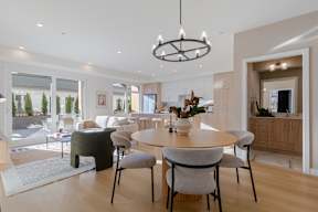 A modern dining room with a round table and chairs in Hillcrest Ave located in Abbotsford, BC