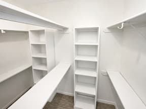 A spacious walk in closet with shelves located at Canfield Lakes Apartments in Houston TX