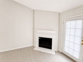 A white fireplace in the living room located at Canfield Lakes Apartments in Houston TX