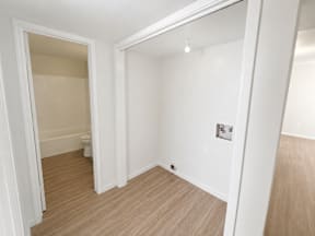 A white bathroom with a toilet and a wooden floor located at Canfield Lakes Apartments in Houston TX