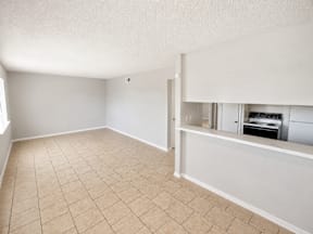 A large living room with tiled flooring located at the pointe apartments in Pasadena, Tx
